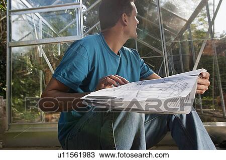 Man with greenhouse plans in garden View Large Photo Image Stock Image - Man with greenhouse plans in garden. Fotosearch