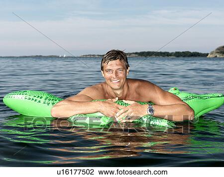 Man with inflatable crocodile View Large Photo Image Stock Image - Man with inflatable crocodile. Fotosearch