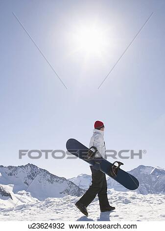 Stock Image - man with snowboard on top of mountain. Fotosearch