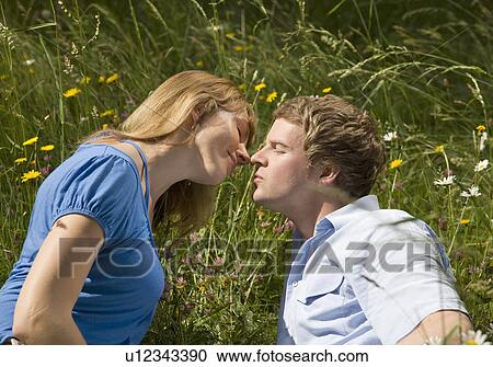 man, woman kissing in grass with flowers View Large Photo Image Stock Image - man, woman kissing in grass with flowers. Fotosearch