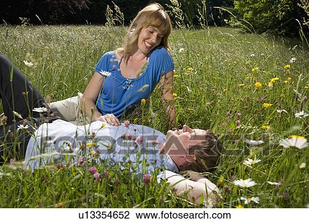man, woman lying in grass with flowers View Large Photo Image Stock Image - man, woman lying in grass with flowers. Fotosearch