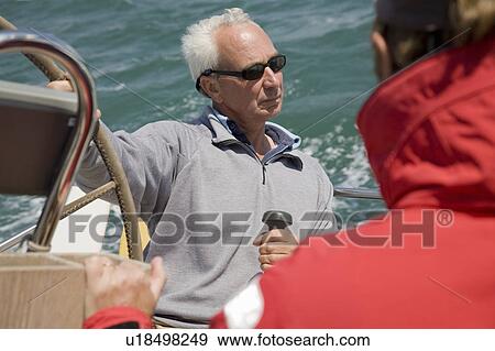 Stock Photo - Mature couple sailing yacht. Fotosearch