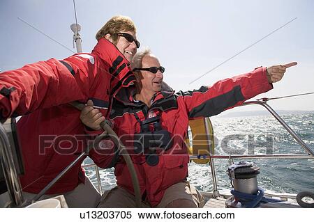 Stock Photography - Mature couple sailing yacht. Fotosearch