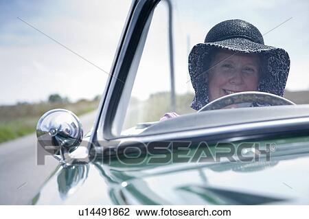 Stock Image - Mature lady driving car. Fotosearch