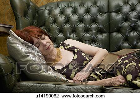 Stock Image - Mature lady Sleeping on couch. Fotosearch