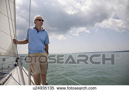 Mature man standing on a yacht View Large Photo Image Stock Photography - Mature man standing on a yacht. Fotosearch