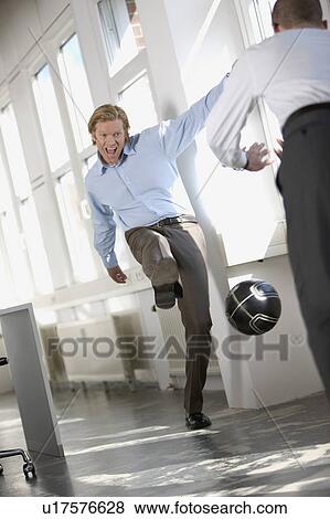 men are playing soccer in an office View Large Photo Image Stock Photo - men are playing soccer in an office. Fotosearch