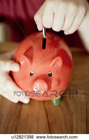 Money being put in a piggy bank View Large Photo Image Stock Photo - Money being put in a piggy bank. Fotosearch