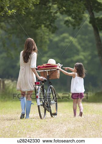 Mother and child with bike and picnic View Large Photo Image Stock Image - Mother and child with bike and picnic. Fotosearch