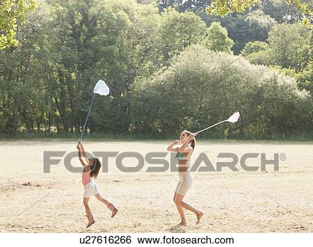 Mother and daughter in field with nets View Large Photo Image Stock Photograph - Mother and daughter in field with nets. Fotosearch