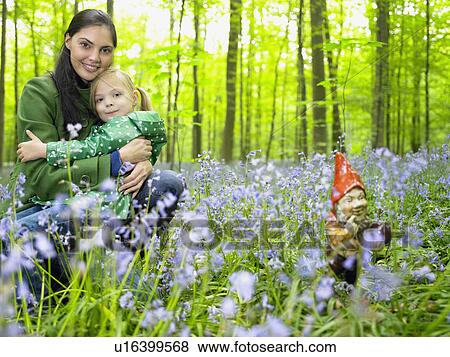 Stock Photo - Mother and daughter next to garden gnome. Fotosearch