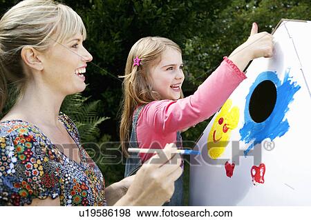 Stock Photo - Mother and daughter painting together. Fotosearch