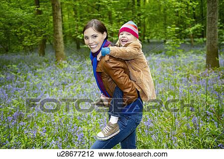 Stock Image - Mother and daughter playing in the woods. Fotosearch