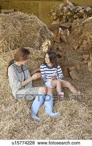 Mother and daughter sitting in hay View Large Photo Image Stock Photo - Mother and daughter sitting in hay. Fotosearch