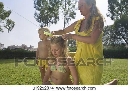 Mother brushing daughter's hair View Large Photo Image Picture - Mother brushing daughter's hair. Fotosearch