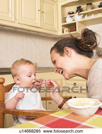 Stock Photography - mother feeding baby. Fotosearch