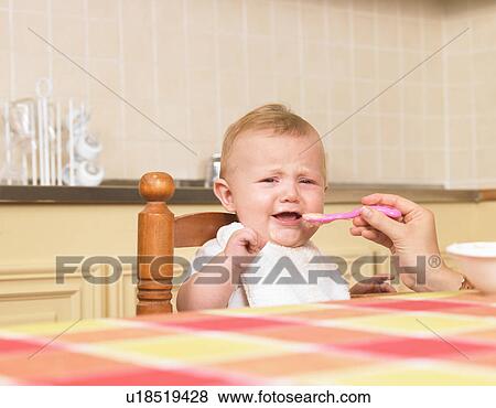 mother feeding unhappy baby View Large Photo Image Stock Photo - mother feeding unhappy baby. Fotosearch