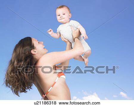 Stock Photo - mother holding baby up in air. Fotosearch