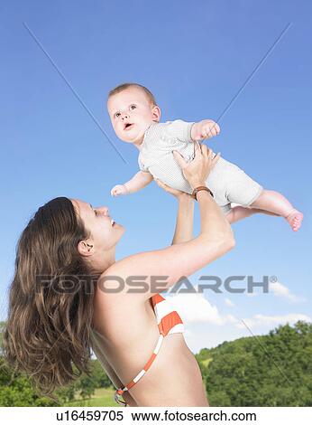 mother holding baby up in air View Large Photo Image Stock Photography - mother holding baby up in air. Fotosearch