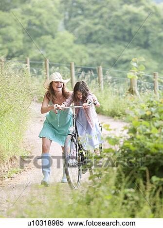 Mother with daughter on bicycle View Large Photo Image Stock Photography - Mother with daughter on bicycle. Fotosearch