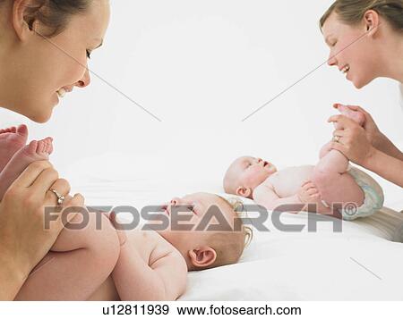 Stock Photo - mothers playing with babies. Fotosearch
