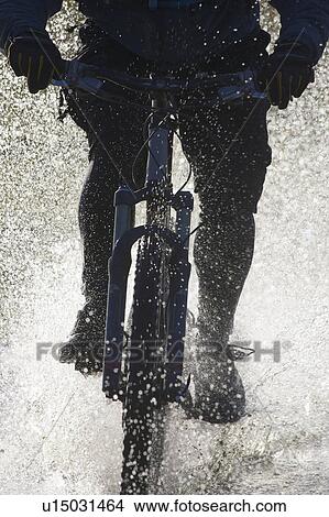 Mountain bike riding through water. View Large Photo Image Picture - Mountain bike riding through water.. Fotosearch