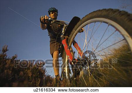 Picture - Mountain biker riding on a trail. Fotosearch