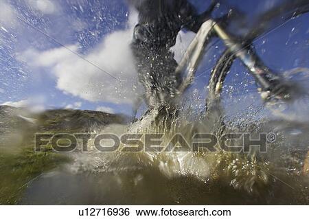 Mountain biker riding through a puddle. View Large Photo Image Stock Photograph - Mountain biker riding through a puddle.. Fotosearch