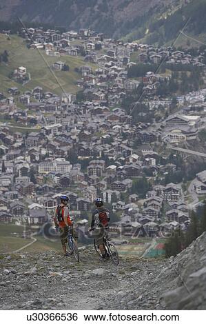 Stock Photograph - Mountain bikers resting in the alps. Fotosearch