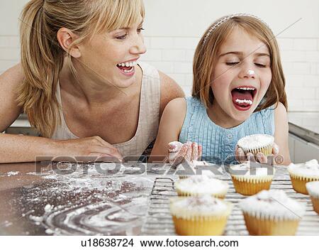 Picture - Mum and daughter with cakes. Fotosearch
