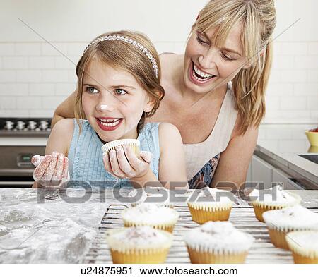 Stock Image - Mum and daughter with cakes. Fotosearch