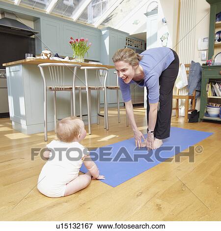 Stock Photo - mum doing yoga with a baby. Fotosearch