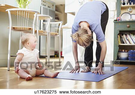 Stock Photography - mum doing yoga with a baby. Fotosearch