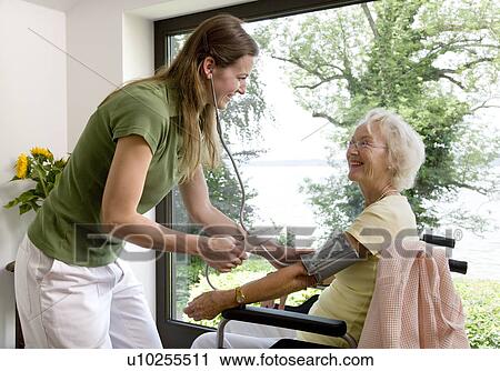 Stock Image - nurse taking woman's blood pressure. Fotosearch