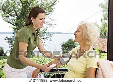 Stock Photo - nurse taking woman's blood pressure. Fotosearch