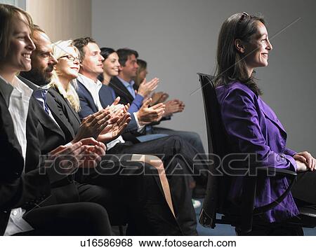 Stock Photo - People at a conference, applauding. Fotosearch
