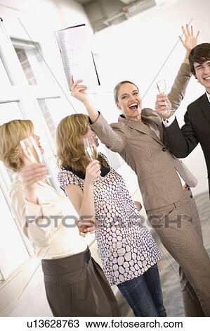 Stock Image - people drinking champagne in an office. Fotosearch