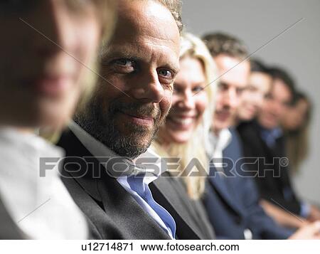 Stock Image - People looking at camera at a conference. Fotosearch