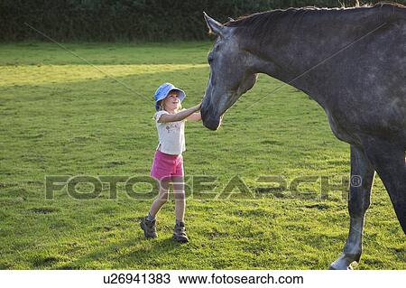 Stock Image - Petting the horse. Fotosearch