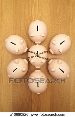 Stock Photograph - piggy banks surrounding piggy in chains. Fotosearch