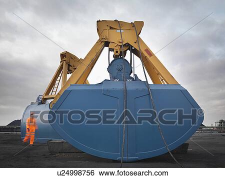 Stock Photograph - Port Worker And Heavy Machinery. Fotosearch