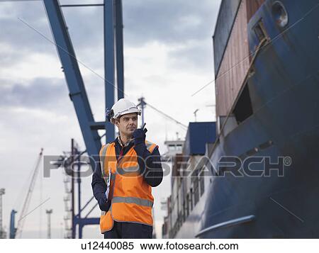 Stock Photography - Port Worker Beside Loaded Ship. Fotosearch