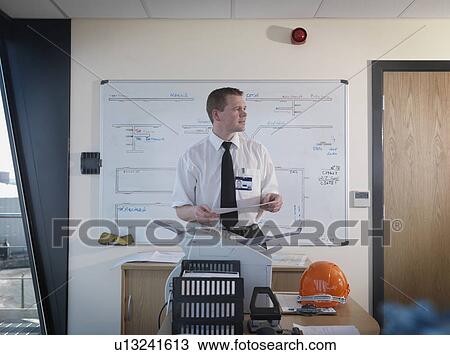 Stock Image - Port Worker In Control Tower Office. Fotosearch