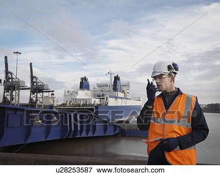 Stock Photo - Port Worker In Front Of Container Ship. Fotosearch