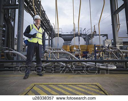 Stock Photo - Port Worker In Front Of Pipes. Fotosearch