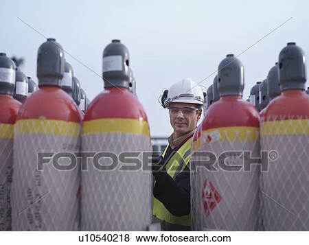 Stock Photo - Port Worker Inspecting Gas Canisters. Fotosearch
