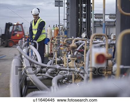Stock Photography - Port Worker Inspecting Pipe Work. Fotosearch