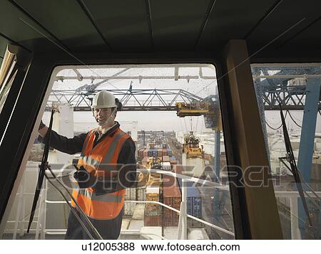 Stock Photo - Port Worker Overseeing Loading Of Ship. Fotosearch