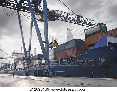 Stock Photo - Port Worker Watching Ship Being Loaded. Fotosearch