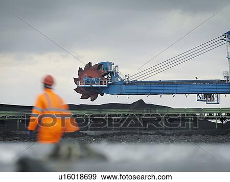 Stock Photo - Port Worker With Heavy Machinery. Fotosearch